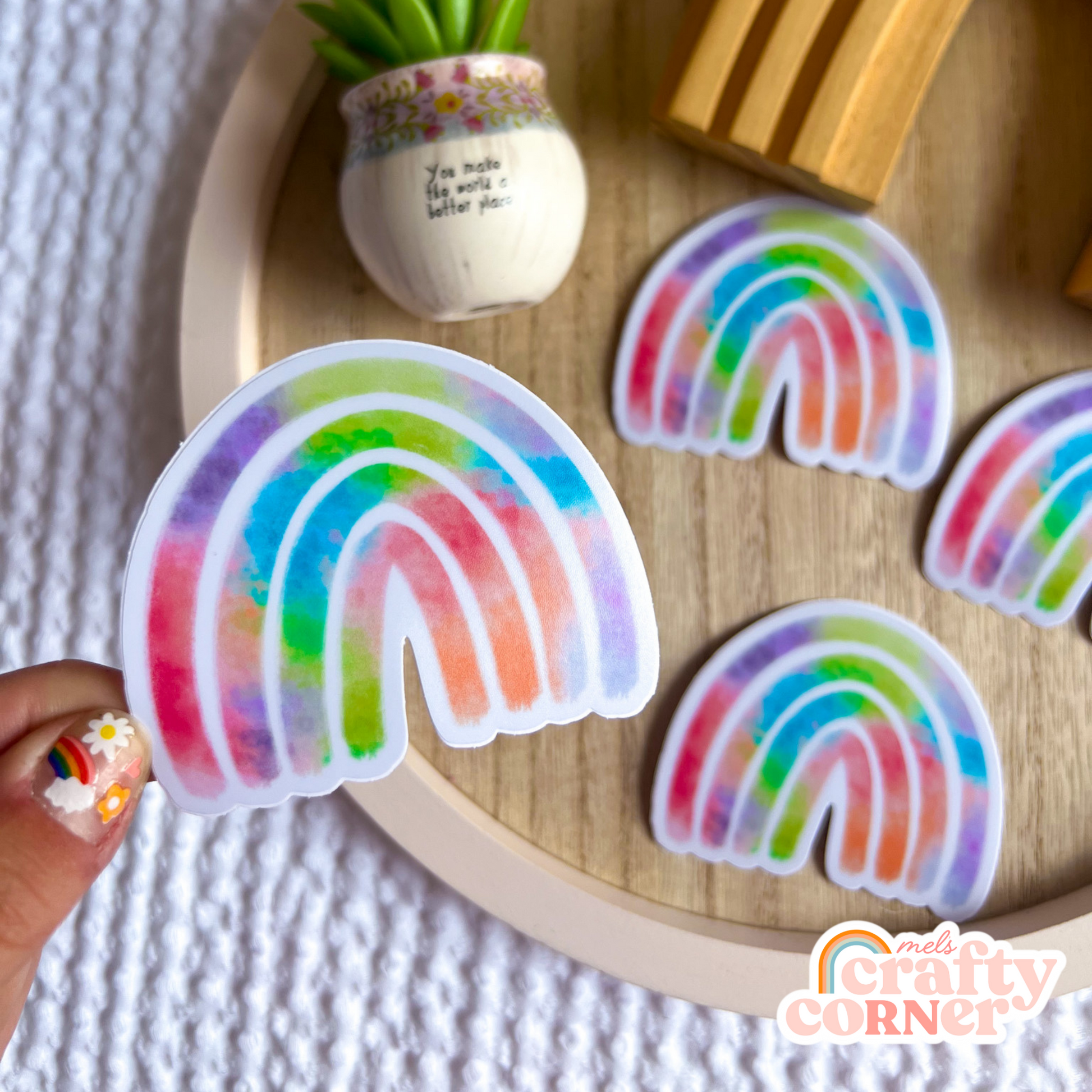Hand holding Rainbow colorful matte sticker showing size and scale by Mel's Crafty Corner