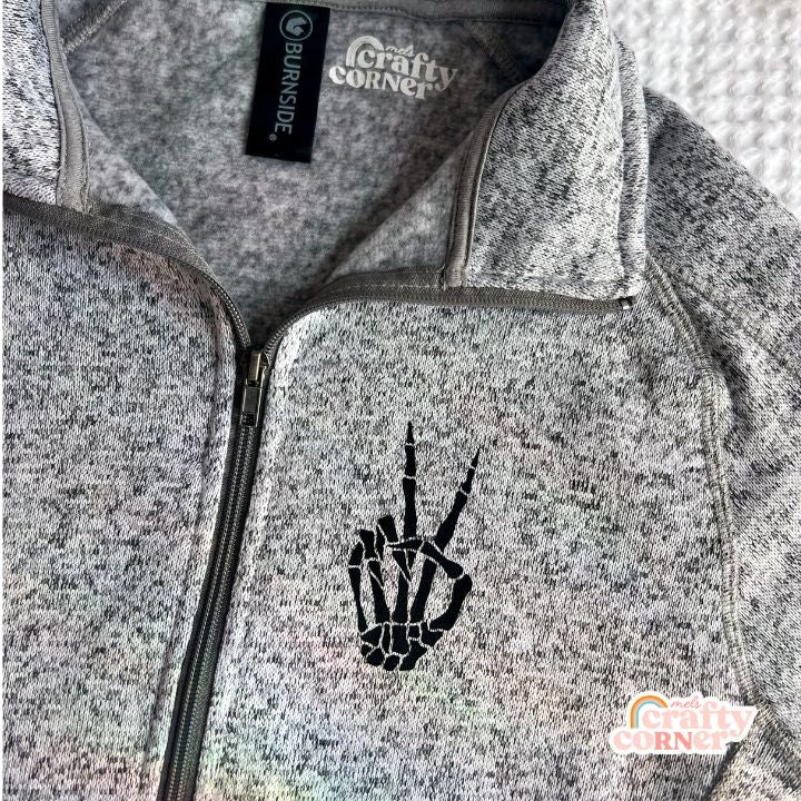 Flat lay view of heather grey Build Your Boneyard fleece zip-up jacket by Mel's Crafty Corner