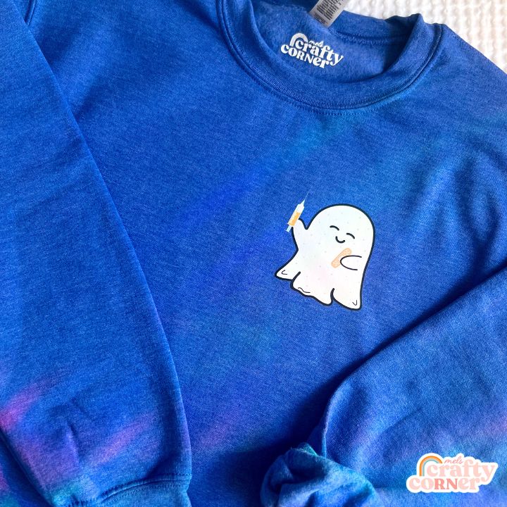 Flat lay view of heather royal Boo-Boo Ghostie classic crewneck sweatshirt by Mel's Crafty Corner