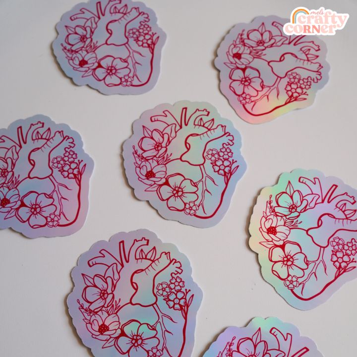 Hand holding Floral Anatomical Heart red holographic sticker showing size and scale by Mel's Crafty Corner