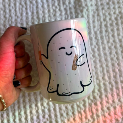 Hand holding Boo-Boo Ghostie 15 oz ceramic mug showing size and scale by Mel's Crafty Corner