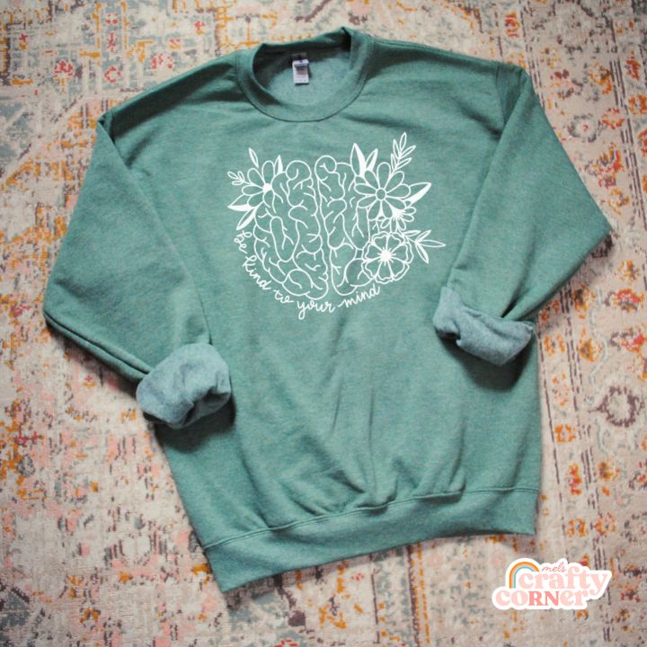 Flat lay view of green Be Kind To Your Mind classic crewneck sweatshirt by Mel's Crafty Corner