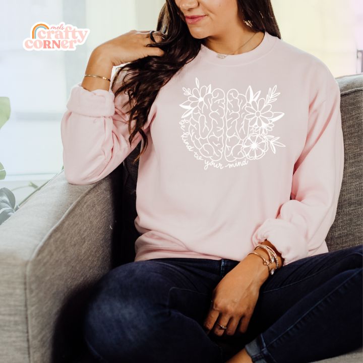 Model wearing light pink Be Kind To Your Mind classic crewneck sweatshirt by Mel's Crafty Corner