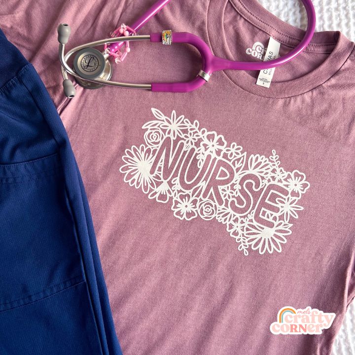 Orchid-colored Floral Nurse soft t-shirt laid flat