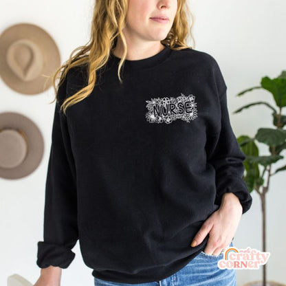 Model wearing black Pocket Floral Nurse classic crewneck sweatshirt by Mel's Crafty Corner